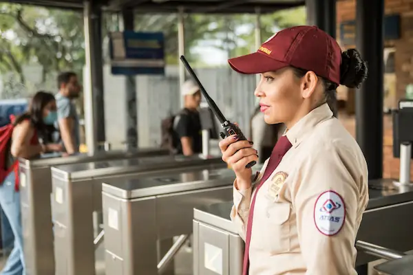 Guardiana de seguridad Atlas en entrada de universidad en Bogotá controlando acceso con radio