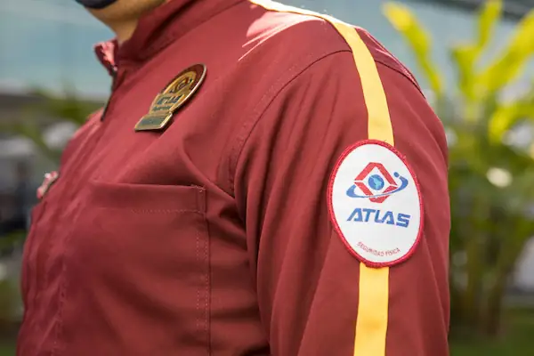 Detalle de uniforme oficial Atlas Seguridad Física con parche bordado y escarapela en Bogotá